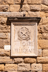 Old post office sign with a Socialist star in Volterra