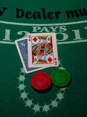 Blackjack cards with a king face up on a backjack table with poker chips