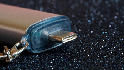 USB type-c connector on a spectacular dark sparkling background. OTG adapter. Keychain. Close-up....