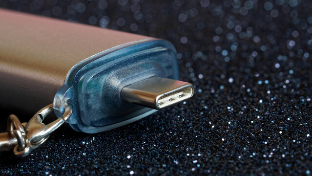 USB type-c connector on a spectacular dark sparkling background. OTG adapter. Keychain. Close-up. Photo. Shallow depth of field. Copy space