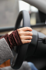 hand gripping a steering wheel while driving a car, focused and in control