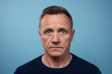 Portrait of a middle aged man with shocked facial expression on blue background