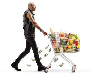 Full length profile shot of a punk walking with a shopping cart full of food and losing money