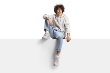 Guy with curly hair sitting on a panel and smiling