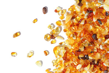 Natural gemstone amber texture background, small stones yellow orange color isolated on white. Natural mineral material for jewelry. Top view Aesthetic Amber textured, pieces ancient resin