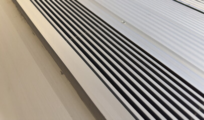 air vent system, silver grilles on white wall, essential for fresh indoor air, HVAC technology...