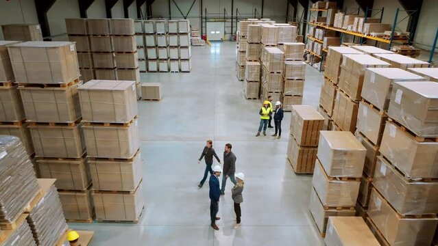 Top view of warehouse workers in warehouse. Team of warehouse workers preparing products for shipment, checking delivery, stock in warehouse.