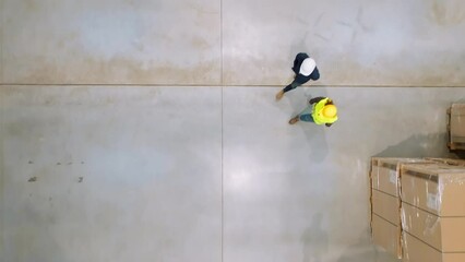 Top view of warehouse workers in warehouse. Team of warehouse workers preparing products for shipment, checking delivery, stock in warehouse. - Powered by Adobe