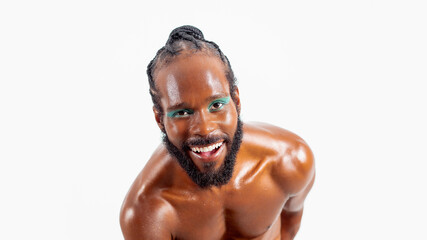 Smiling african-american bearded gay man with bright makeup isolated on white background. Exudes...