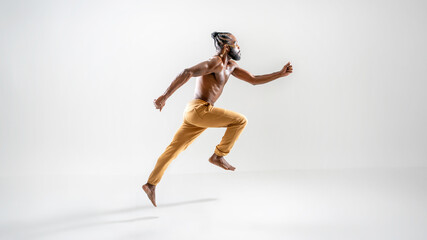 Fototapeta na wymiar Profile side view male gay athlete runner jogging isolated on white background. Gender equality right concept. Shirtless barefoot african-american homosexual man wearing make up running. Full length
