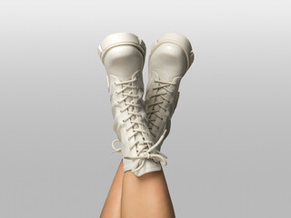 Crossed female legs in white combat boots upside down isolated on white gray background. Woman...