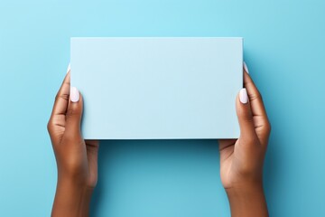 A person of color's hands holding a blue box