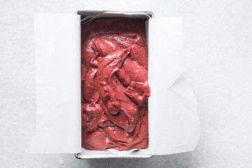Top view of Red velvet cake batter in a silver loaf tin, process of making valentines cake, red velvet loaf cake in a baking tin