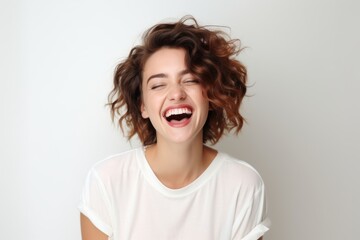 Portrait of beautiful young woman with curly hair laughing and looking at camera