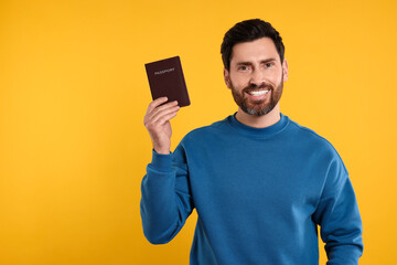 Immigration. Happy man with passport on orange background, space for text