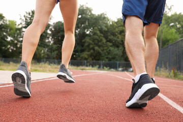 Healthy lifestyle. Sporty couple running at stadium, closeup