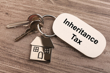 Inheritance Tax. Card and keys with key chain in shape of house on wooden table, top view
