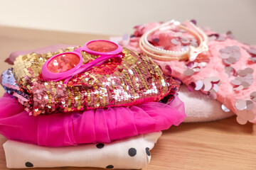 Stylish carnival costume with sequins, sunglasses and headbands on wooden table, closeup
