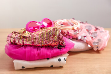Stylish carnival costume with sequins, sunglasses and headbands on wooden table