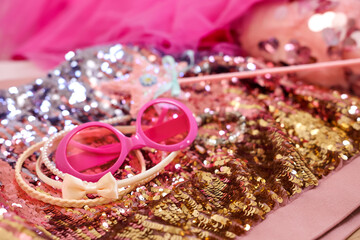 Stylish carnival costume with sequins, sunglasses, wand and headbands, closeup