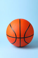 Obraz premium One orange basketball ball on light blue background