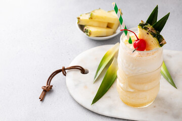 Tropical tiki cocktail pina colada in a fun glass garnished with pineapple