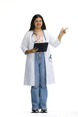 A female doctor, on a white background, in full height, points to the side © Katsiaryna