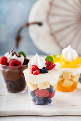 Three desserts in cups, variety of trifles with orange, chocolate and berry