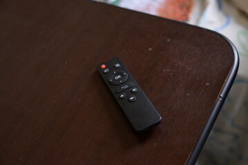 Controle remoto de televisão preto em cima da mesa © LuanLeonel