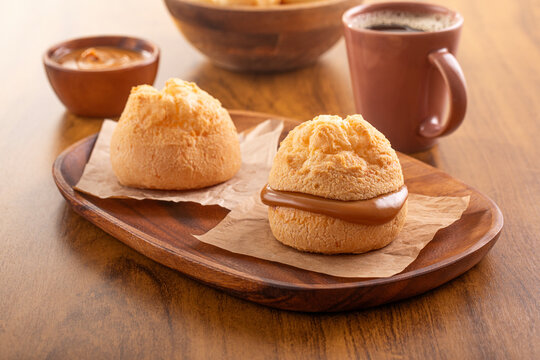 Brazilian snack. P&atilde;o de Queijo filled with dulce de leche. Black coffee. Breakfast.