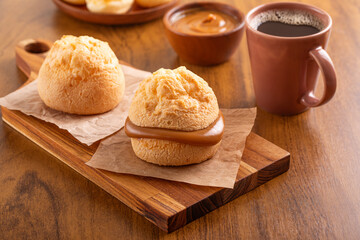 Brazilian snack. Pão de Queijo filled with dulce de leche. Black coffee. Breakfast.