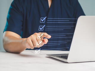 Businessman pointed to the checklist on an online document list while sitting at a desk.