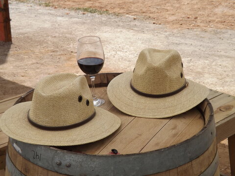 Sombreros de vendimia junto a copa de vino
