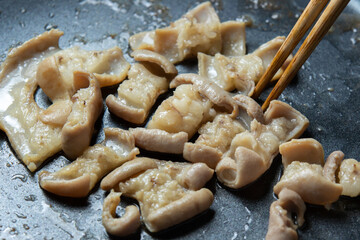 ホルモン(牛もつ･牛小腸)をフライパンで焼く調理シーン。
