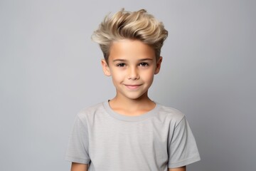 Portrait of a cute little boy with short blond hair in a gray t-shirt.