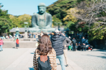 Woman tourist Visiting in Kamakura, Kanagawa, Japan. happy Traveler sightseeing the Great Buddha statue. Landmark and popular for tourists attraction near Tokyo. Travel and Vacation concept