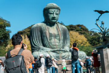 man tourist Visiting in Kamakura, Kanagawa, Japan. happy Traveler sightseeing the Great Buddha statue. Landmark and popular for tourists attraction near Tokyo. Travel and Vacation concept