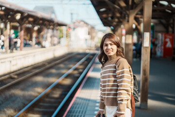 Woman tourist waiting train and Visiting in Kamakura, Kanagawa, Japan. happy Traveler sightseeing...