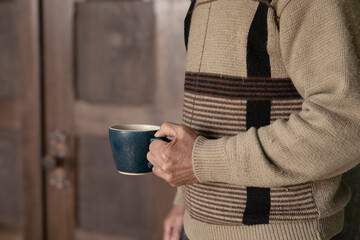 Senior man having coffee at home.  家でコーヒーを持つシニア男性