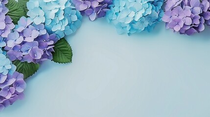 A flat lay of blue and purple hydrangea flowers with light blue shaded copy space