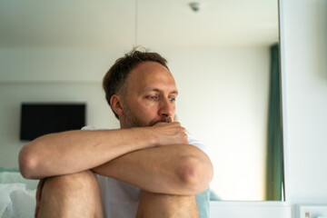 Sad middle age man alone at home. Emotional stress, burnout and midlife crisis concept.