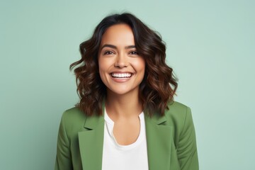 Portrait of happy smiling young woman in green jacket, over green background