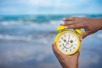 yellow clock on the beach vacation fun time