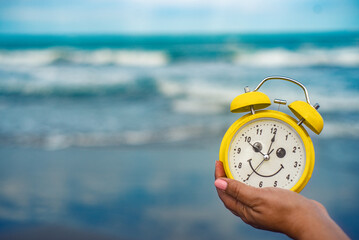 yellow clock on the beach vacation fun time