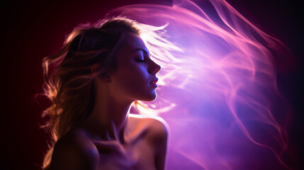 A woman's hair glows as it flows in the wind, backlit by dramatic and vivid lighting.