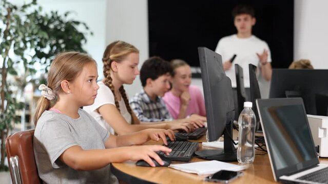 Portrait of female teenage student at computer in school computer class