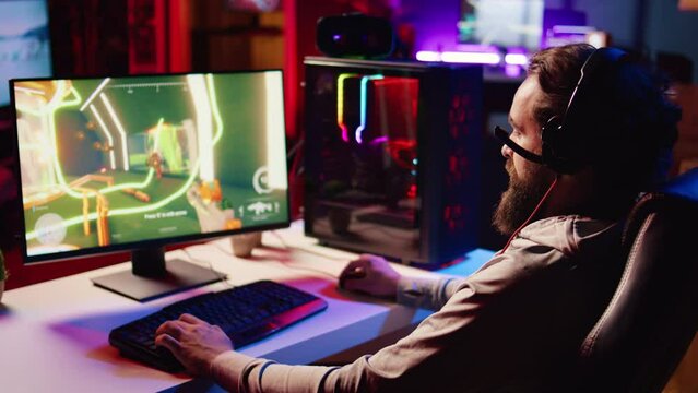 Happy pro gamer at home competing in intense multiplayer videogame, excitedly yelling after winning. Cheerful man achieving victory in gaming session, overflowing with joy