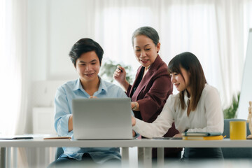 Asian boss or senior employee provide professional help and guidance to intern, practice corporate teamwork communication skill.