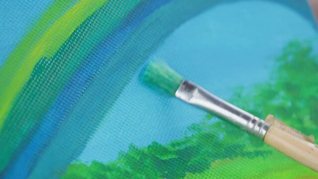 Artist paints pastel masterpiece with skillful gentle brush strokes on canvas