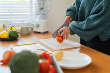Obraz na płótnie Canvas Fat woman cook in kitchen and chopping fresh vegetable on chopping board. health care concept Eat healthy food to lose weight